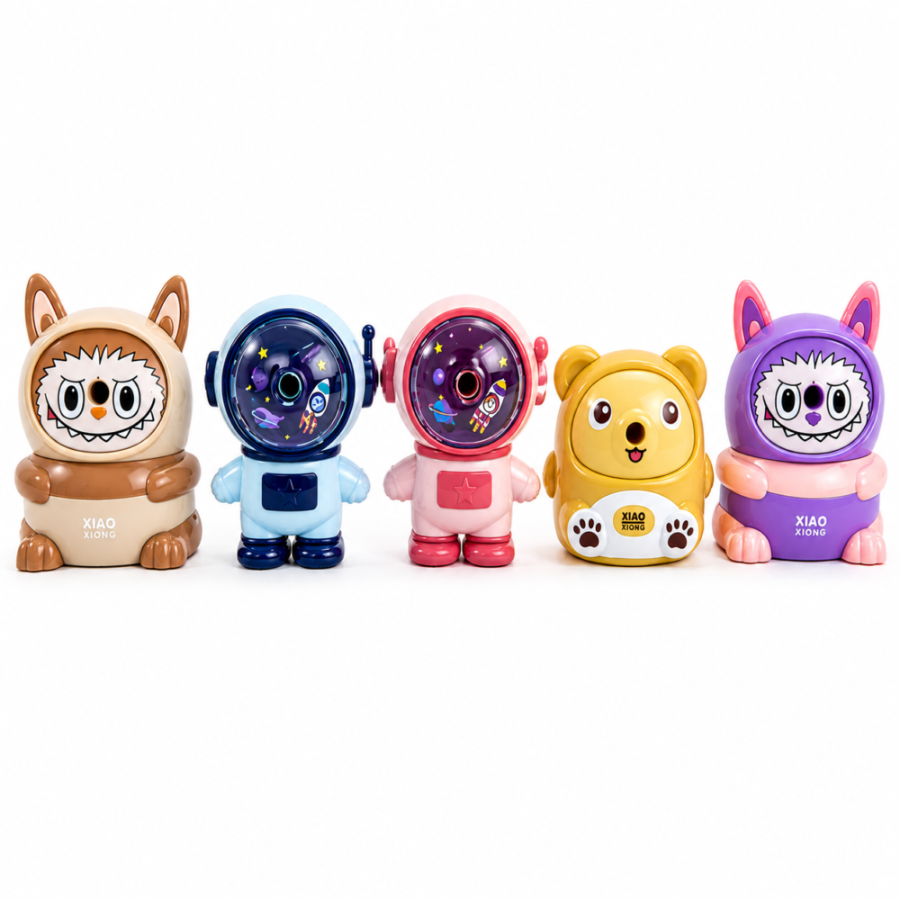 A set of five cute cartoon pencil and crayon sharpeners including a brown monster, a blue astronaut, a pink astronaut, a yellow bear, and a purple monster.